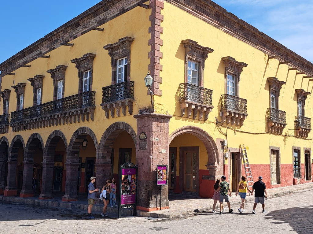 A colonial building in the mandated colours of ochre and yellow on the main square in San Miguel de Allende.